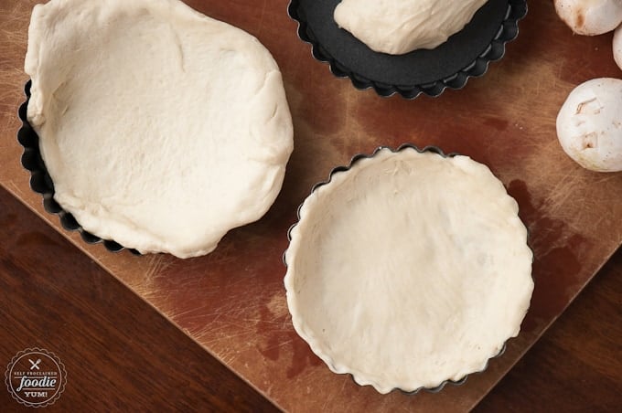pizza dough pressed into small pans