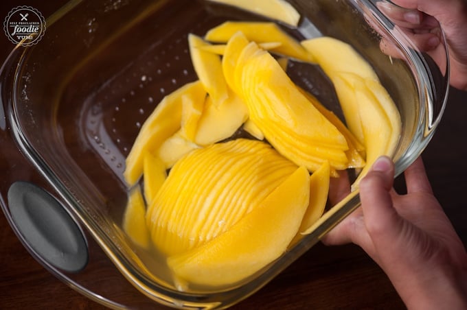 thinly sliced mango in glass pan