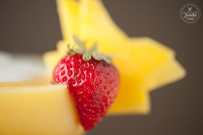 A close up of a strawberry and mango garnish