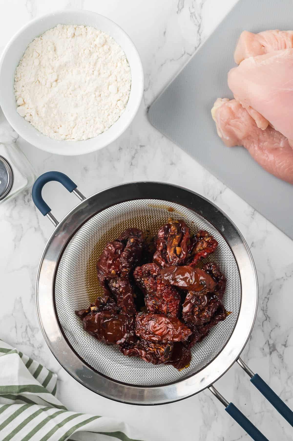 straining sundried tomatoes from oil.