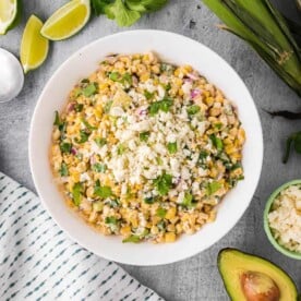 Mexican street corn salad in white bowl.