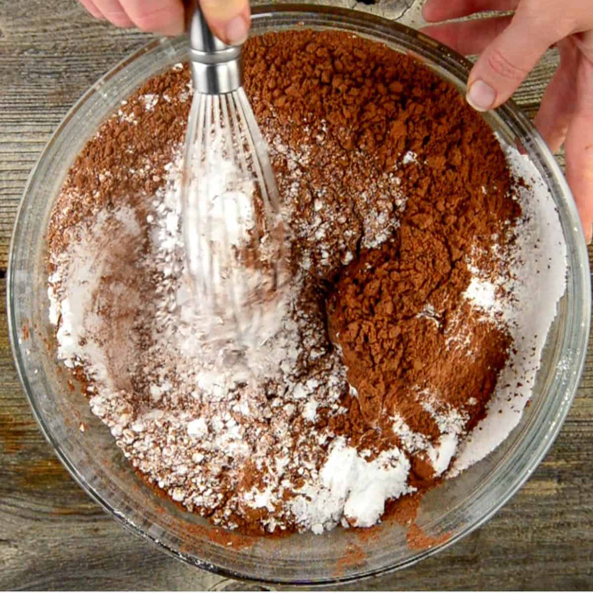 mixing cocoa powder and powdered sugar in glass bowl.