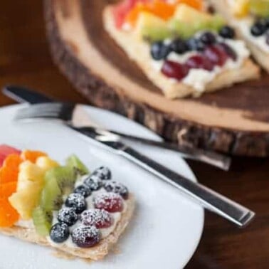 Mini Rainbow Fruit Pizzas transform flaky puff pastry, sweetened mascarpone, & fresh fruit into a colorful sweet treat perfect for breakfast or dessert.