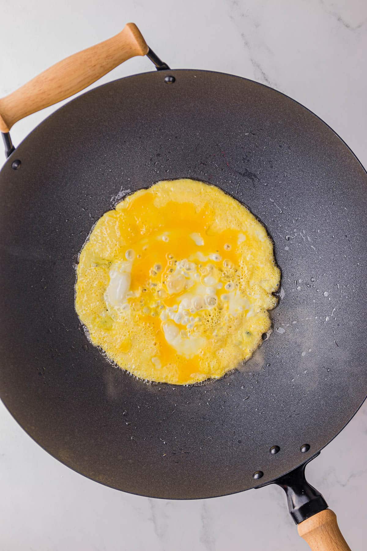 cooking a scrambled egg in a wok.