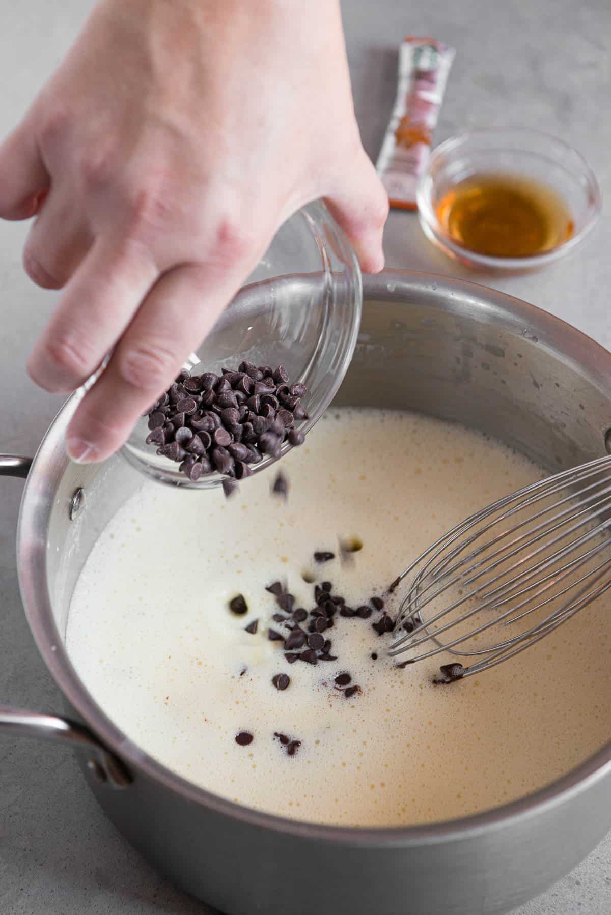 adding mini chocolate chips to warm custard base