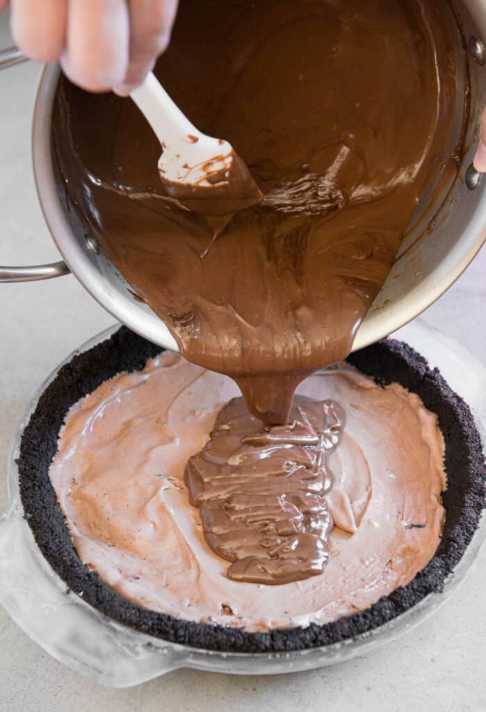 pouring homemade chocolate custard into chocolate pie