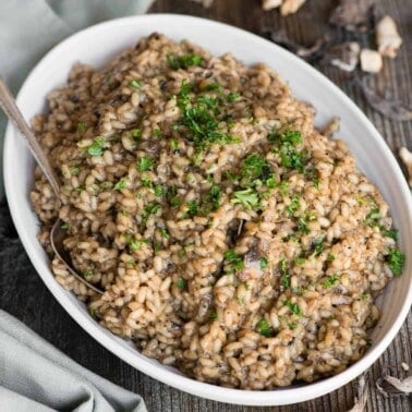 homemade mushroom risotto in a white oval dish.