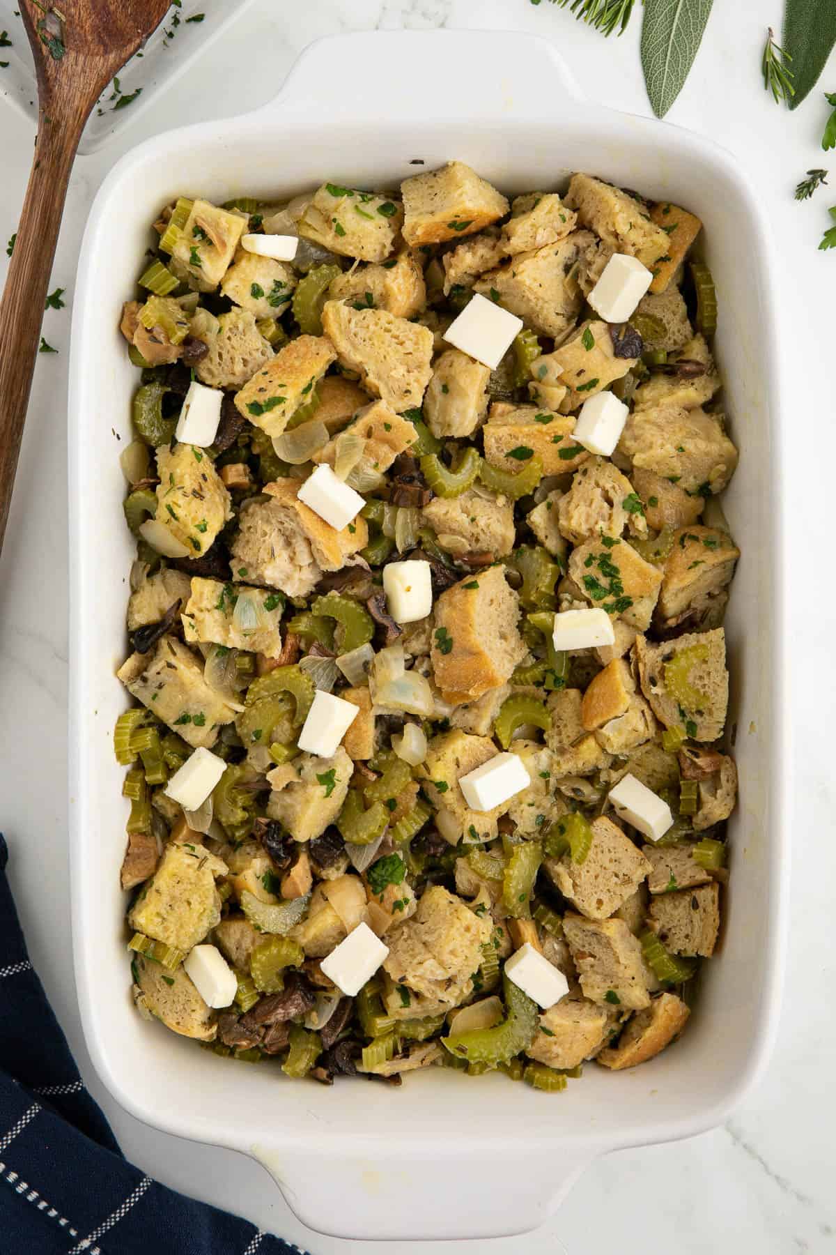 wild mushroom stuffing in casserole dish with butter on top.