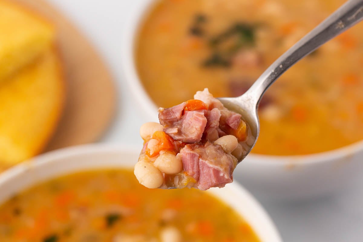 spoonful of homemade navy bean soup with ham.