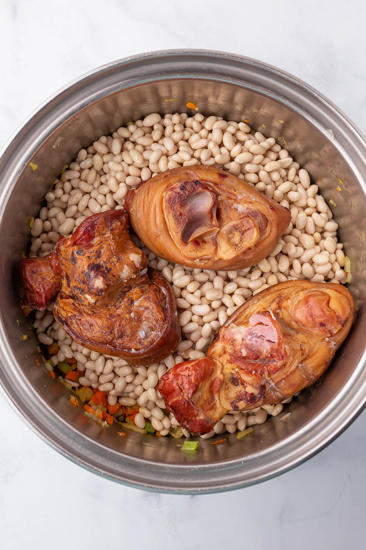 soaked navy beans and ham hocks in pot for navy bean soup recipe.