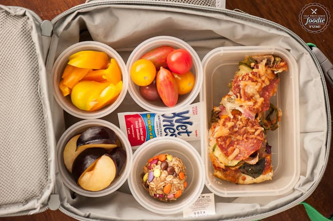 lunchbox with pizza, tomatoes, peppers, plum