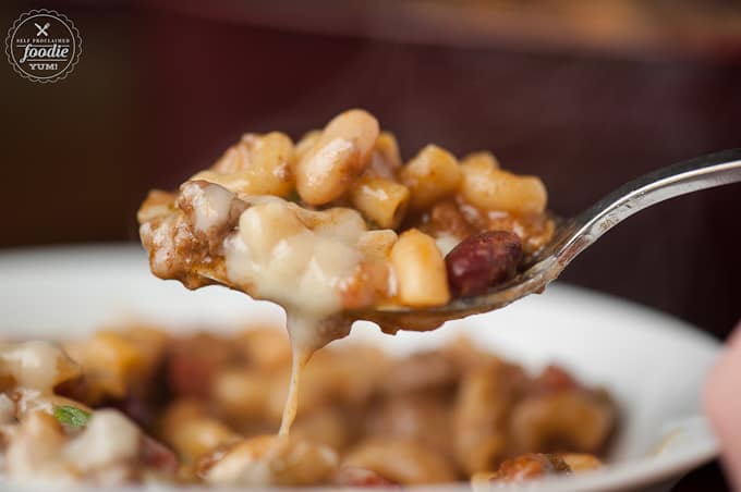 A bite of homemade Chili mac on fork with melted cheese
