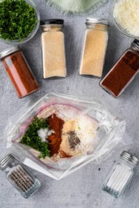 adding spices to bag to flavor chicken breasts.