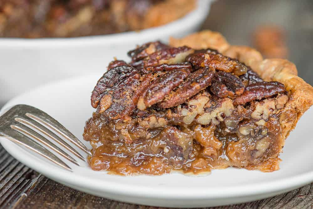 slice of pie with pecan filling on white plate