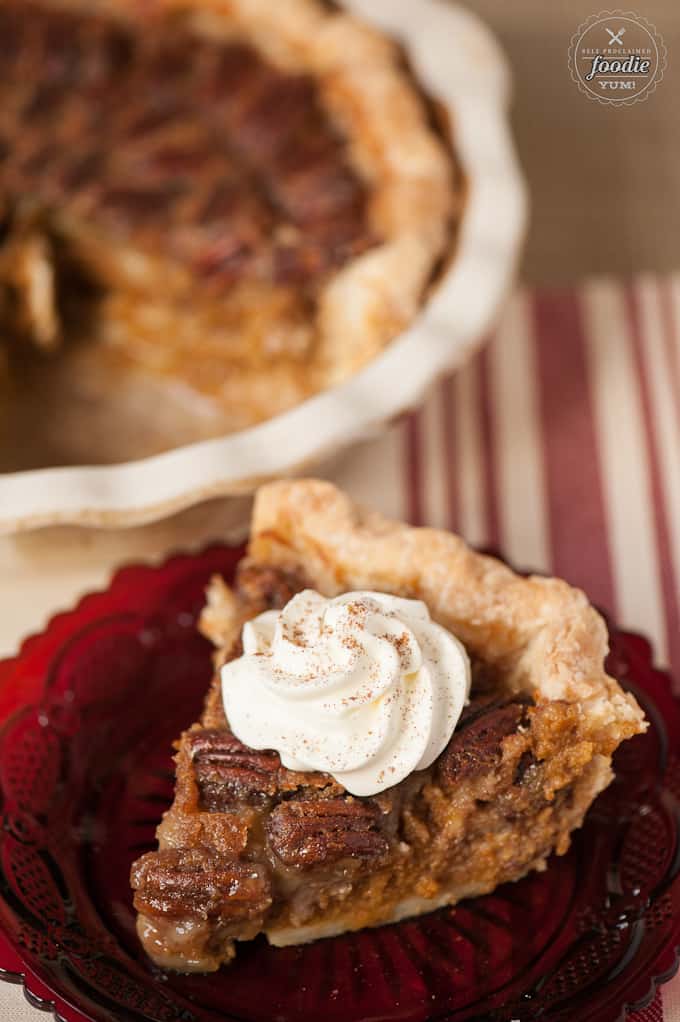 a slice of pumpkin pecan pie with whipped cream on top