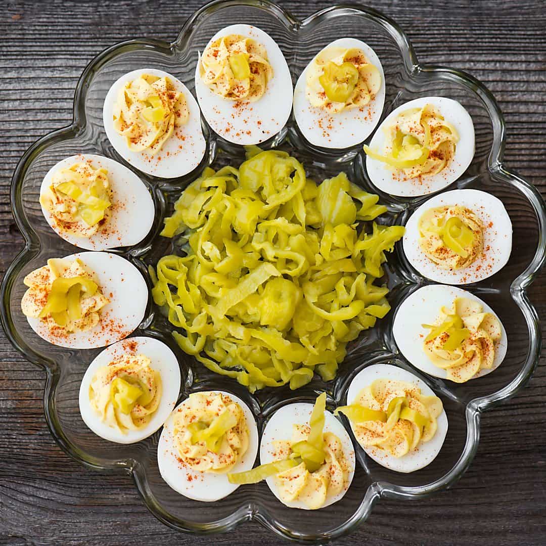 tray of deviled eggs with pepperoncinis in the middle