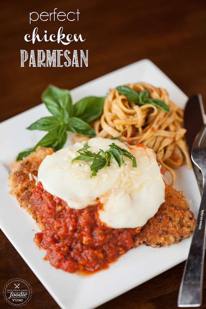 homemade chicken parmesan with pasta on plate with basil