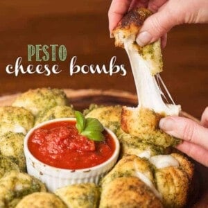 Ooey gooey melty Pesto Cheese Bombs with marinara sauce are super easy to make and will please any crowd. Make this appetizer for your next game day party!