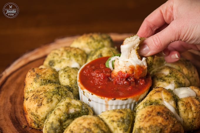 dipping pesto cheese bomb in marinara