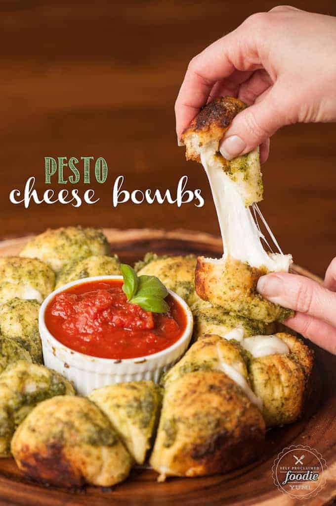 pesto cheese bombs with cheese pull on platter with marinara sauce