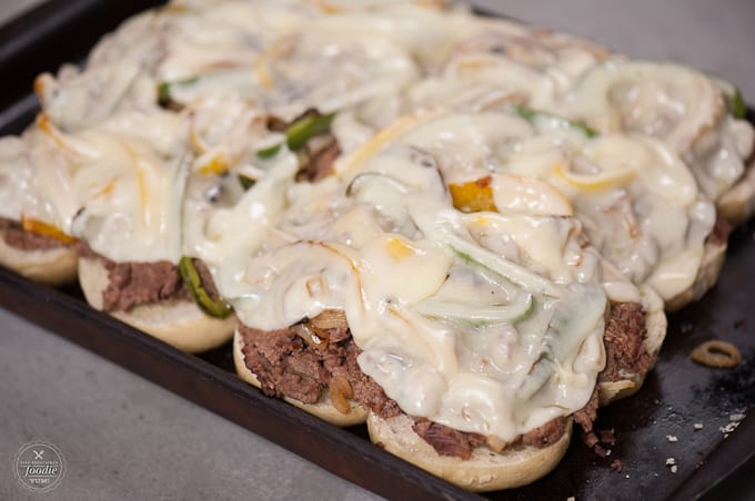 melted cheese on top of philly cheesesteak sliders