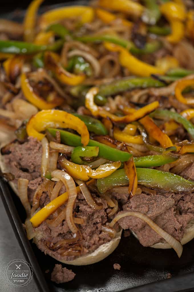 rolls with beef, peppers and onions on top