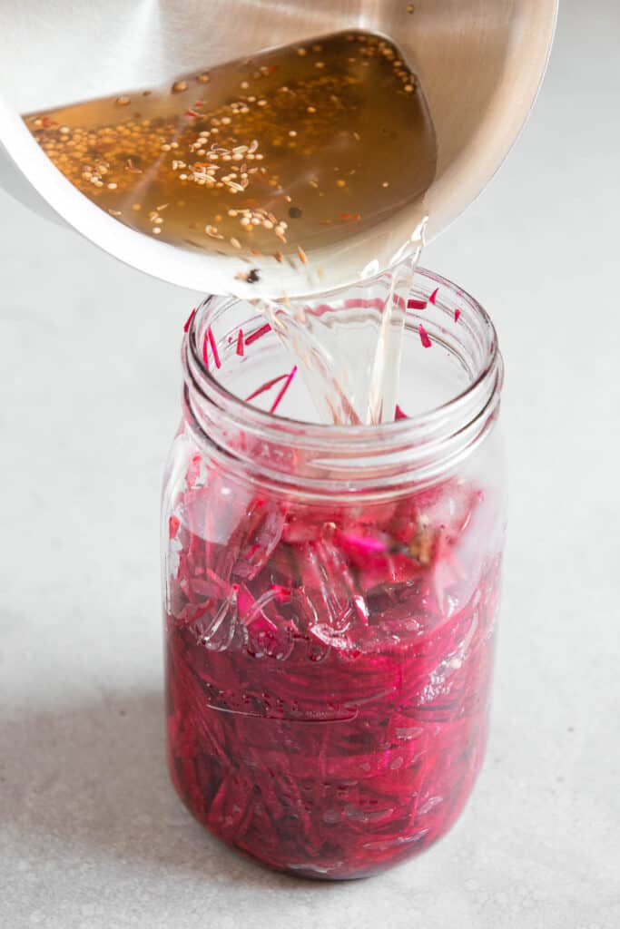 pouring pickling brine over shredded beets