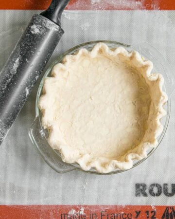 homemade butter pie crust in dish with rolling pin