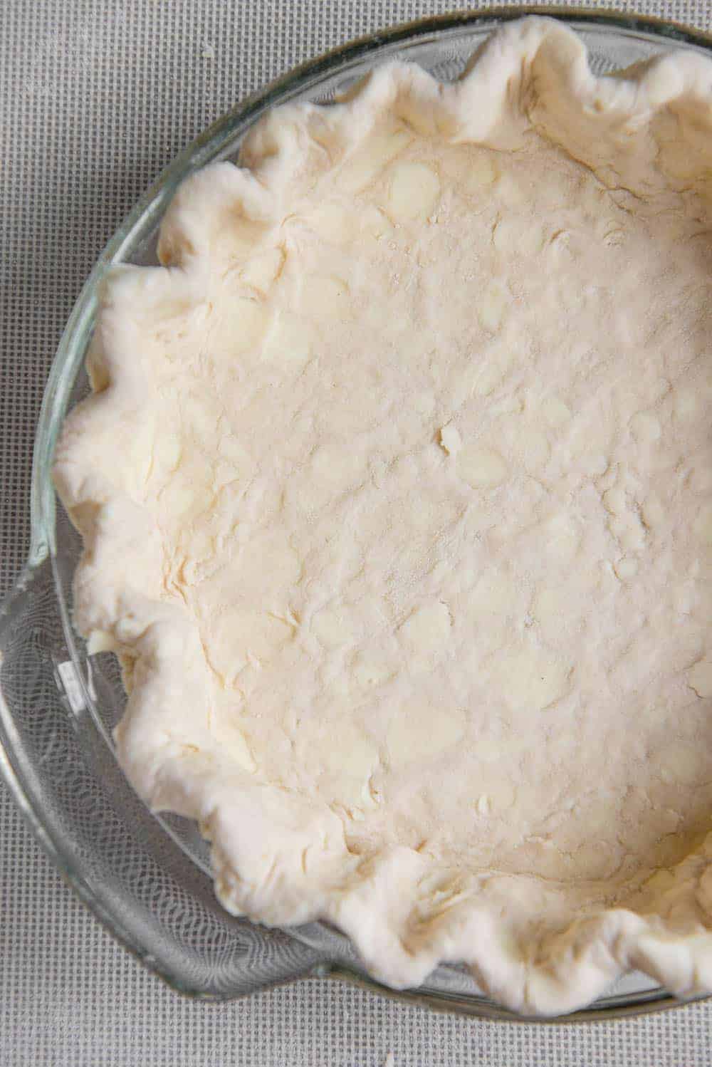 pie crust made with butter in glass pie dish