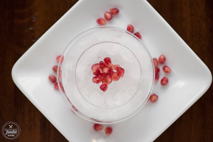 looking down at a glass with pomegranate arils