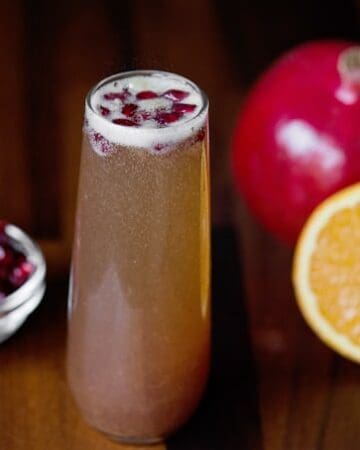 For your next winter celebration, enjoy a tasty Pomegranate Mimosa cocktail, made with pomegranate and orange juice, champagne, and a secret ingredient!