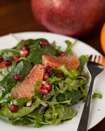 If you're looking for the perfect healthy winter side salad, this Pomegranate Orange Arugula Spinach Salad with a homemade vinaigrette is full of flavor.