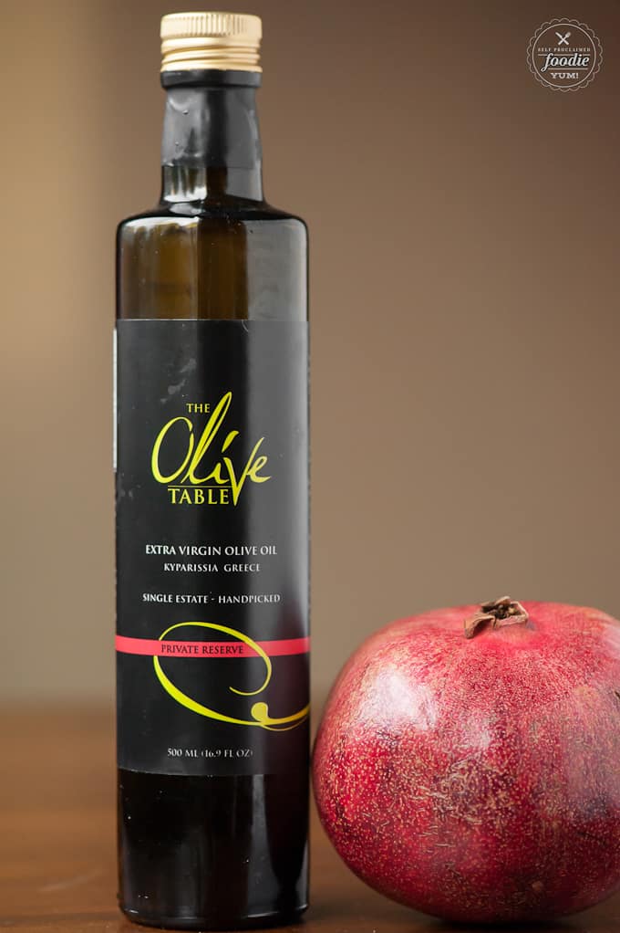 a bottle of olive oil and a pomegranate