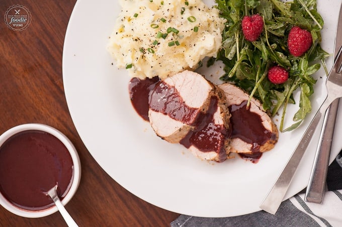 A plate of food on a table, with Pork tenderloin and raspberry Sauce