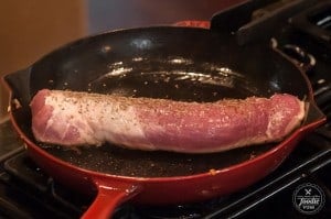 searing a pork tenderloin in a cast iron pan