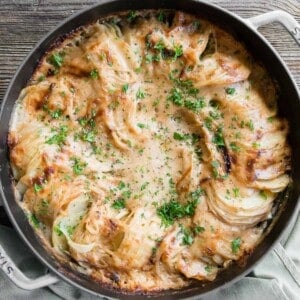 thinly sliced cheesy potatoes au gratin in round Dutch oven.
