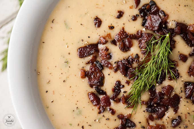 a close up of a bowl of Leek soup topped with bacon