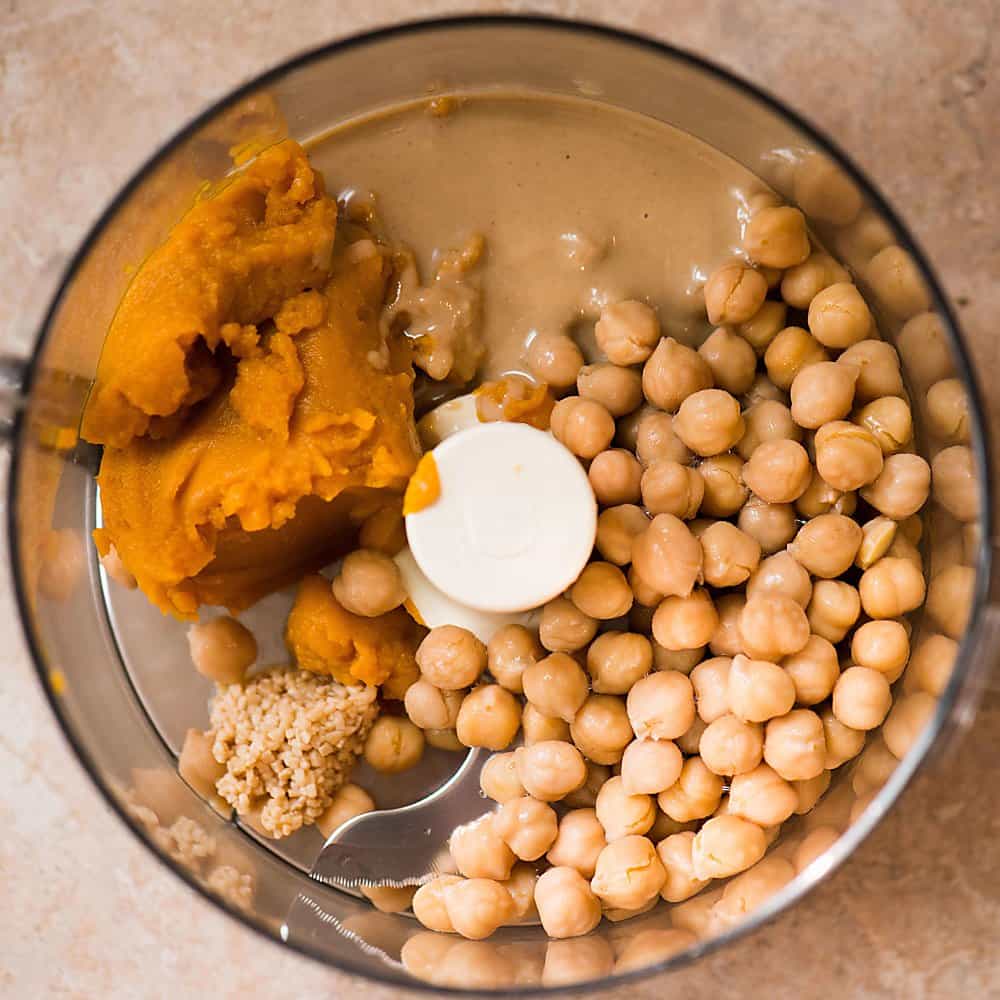 a bowl with the ingredients of pumpkin curry hummus