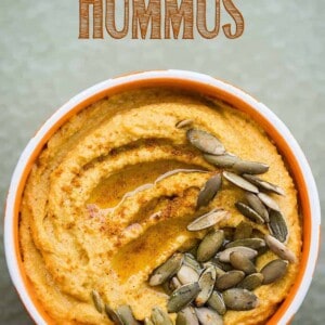 pumpkin curry hummus in a white and orange bowl