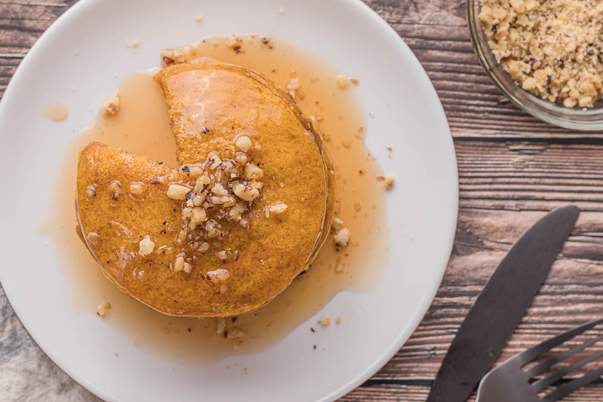top down view of pumpkin pancakes with crushed walnuts.