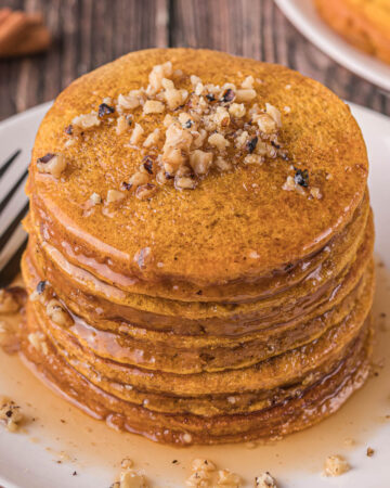Stack of pumpkin pancakes with syrup.