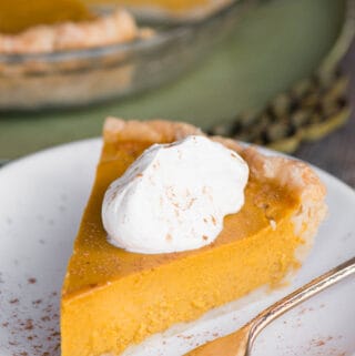 slice of Homemade classic Pumpkin Pie with whipped cream