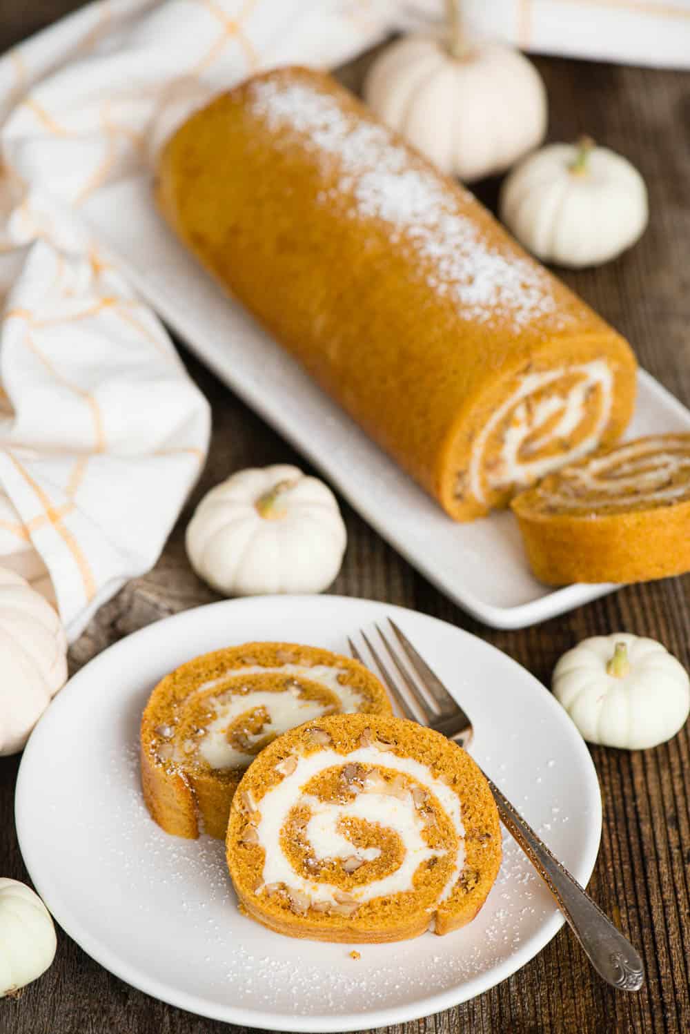 pumpkin spice roll on platter with two pieces on plate