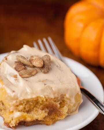 These super soft and delicious homemade from scratch Pumpkin Spice Cinnamon Rolls are made with real pumpkin and have an added pumpkin seed crunch.