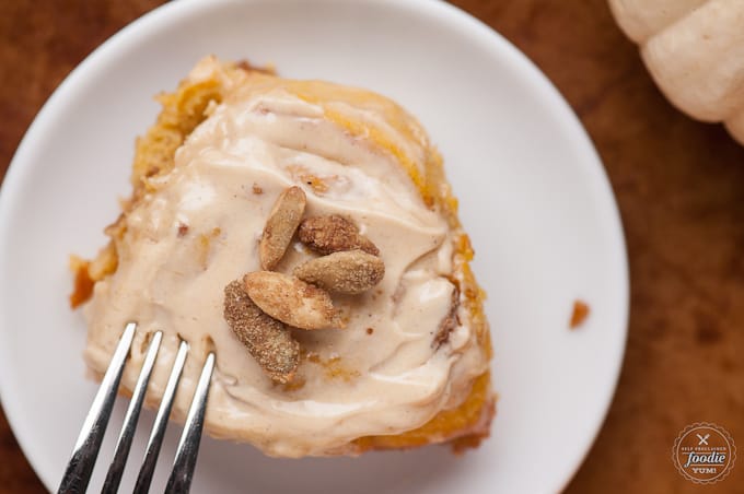 a close up of a pumpkin spice cinnamon roll on a plate