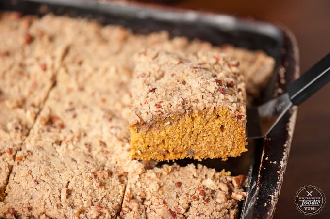 A piece of pumpkin coffee cake with a slice cut out