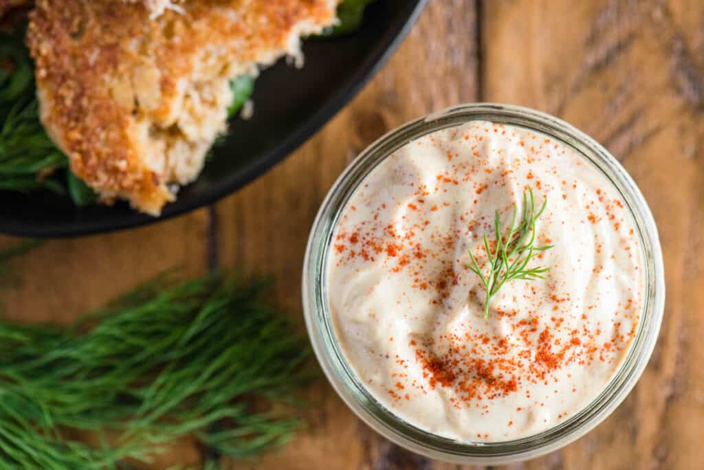 homemade remoulade sauce in mason jar served with crab cakes.