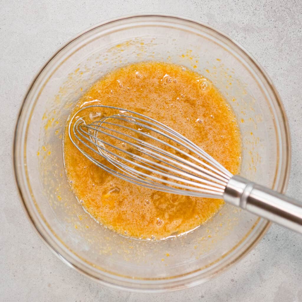 eggs whisked with sugar in glass bowl