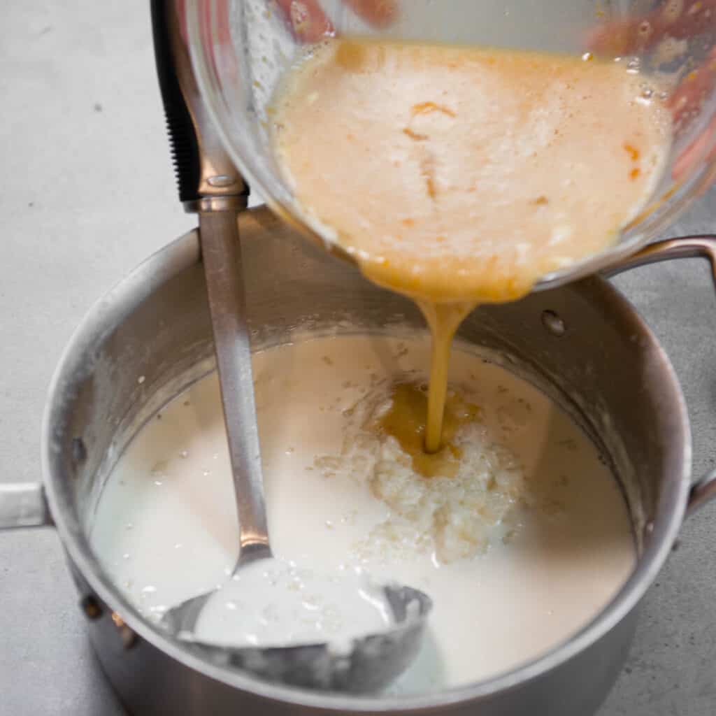 adding tempered egg back to hot milk and rice mixture