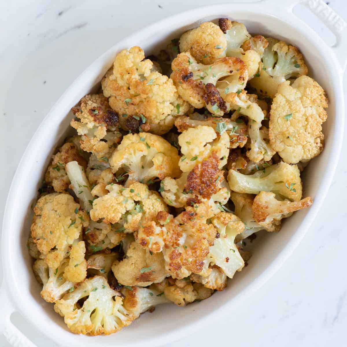 white oval dish with roasted cauliflower.